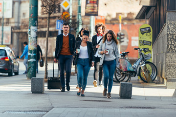Friends Bonding, group of multi-ethnic friends walking on the streets talking to each other and smiling.
