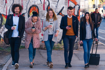 Obraz premium Group of friends (colleagues) hanging out in an urban area.