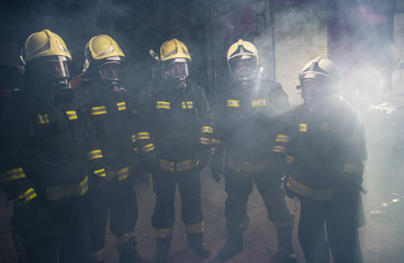 Portrait of group of firefighters in the middle of the smoke of the fire extinguisher