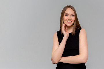 Happy that everything is okay. Portrait of charming friendly caucasian girl with braces smiling cheerfully while standing against monochromatic background, listening order or talking to coworker