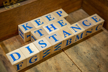 Wooden cubes with lettering Keep the Distance in blue letters