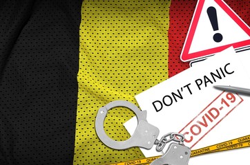 Belgium flag and police handcuffs with inscription Don't panic on white paper. Coronavirus or...
