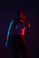 Blue and red light portrait of a female model on a black background with high contrast