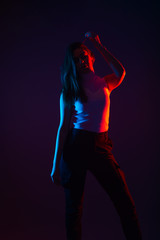 Blue and red light portrait of a female model on a black background with high contrast