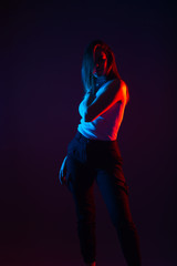 Blue and red light portrait of a female model on a black background with high contrast
