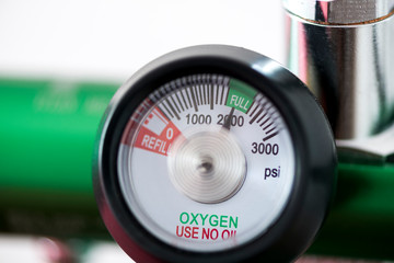 Detail of an oxygen pressure gauge and cylinder with white background