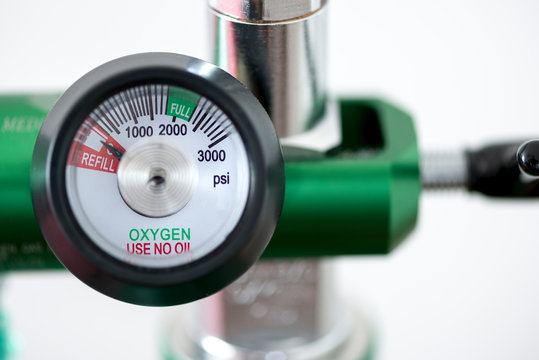 Detail of an oxygen pressure gauge and cylinder with white background