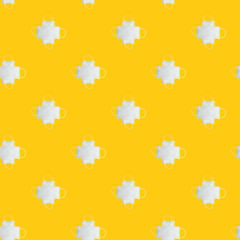 Pattern made of medical surgical masks on yellow background.