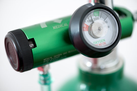 Detail of an oxygen pressure gauge and cylinder with white background