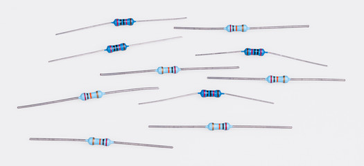 Set of blue miniature carbon resistors on a white background. Group of passive two terminal...