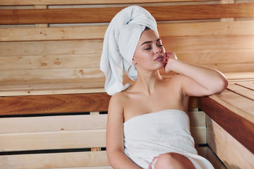 Young beautiful woman have a rest in the sauna. Conception of bodycare