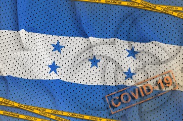 Honduras flag and Covid-19 biohazard symbol with quarantine orange tape and stamp. Coronavirus or...