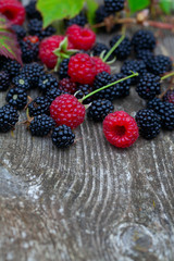 fresh raspberries and blackberries on eustic wooden surface