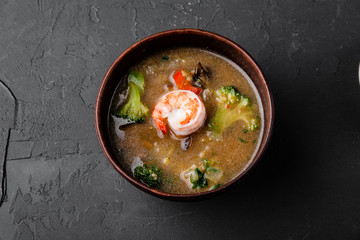 Chinese dishes in a clay plate on a black concrete background with ingredients for delivery