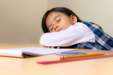 Colombian girl sitting at the desk falls asleep in the classroom while doing the technical drawing task with the rulers