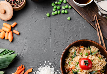 Chinese dishes in a clay plate on a black concrete background with ingredients for delivery