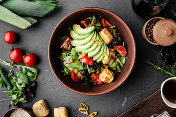 Chinese dishes in a clay plate on a black concrete background with ingredients for delivery