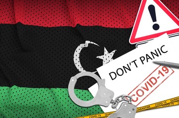 Libya flag and police handcuffs with inscription Don't panic on white paper. Coronavirus or...