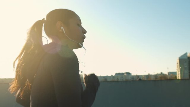 Young woman's side profile while she's jogging at sunset
