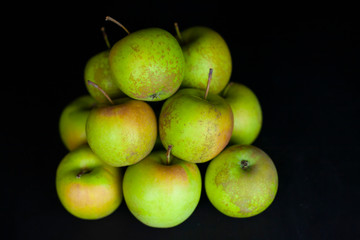 Fresh harvest of green apples on a black background, farm organic fruits
