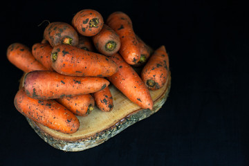 Fresh carrots on a black background, farm organic vegetables