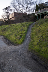 Path leading up grassy hill to buildings