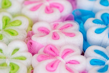 Obraz na płótnie Canvas Multi-colored washcloth in the box. Colorful washcloth. Close-up. Flower sponge. Flower-shaped washcloth