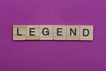 word legend made from  wooden letters lies on a red table