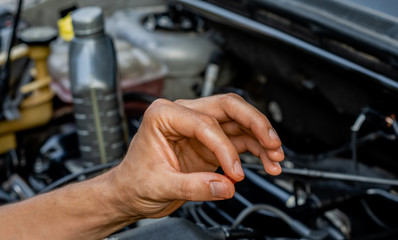 Car repair shop topic: Hand showing oil viscosity for car engine. lubrication and maintenance concept.