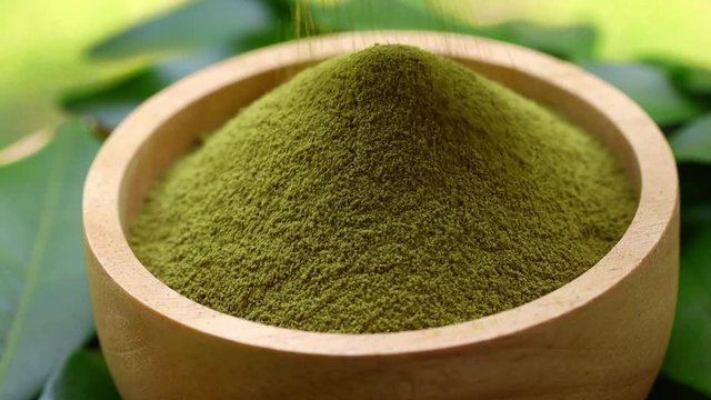 rotation matcha green tea powder in wood bowl