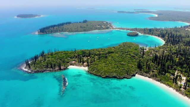 Surrounded by plants of coconut trees and column pines, the beach of Kanumera bay is ideal for snorkeling in the scenario of the Isle of Pines in New Caledonia.
