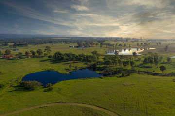 Fototapeta na wymiar An irrigation lake on large green farmland in a rural area