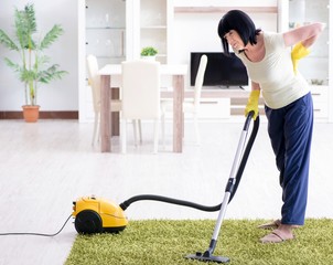 Senior old woman tired after vacuum cleaning house
