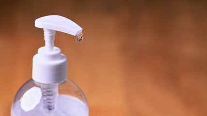 Fototapeta na wymiar Transparent hand sanitizer gel on a wooden background