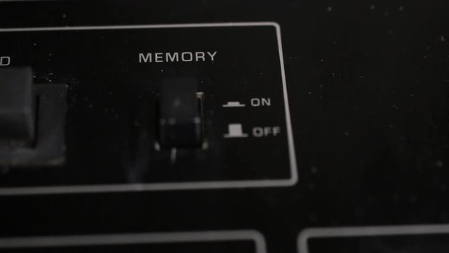 Finger turns the memory button on and off on the old tape recorder.