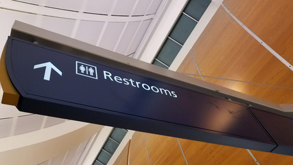 Airport signage showing direction to restrooms for travelers