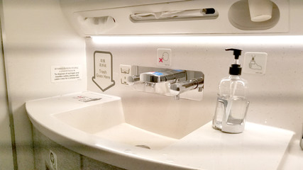 Bathroom sink in a commercial airplane with personal cleaning products