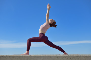 Portrait of a fit woman who practices yoga outdoors. Woman practicing asanas on a sunny day