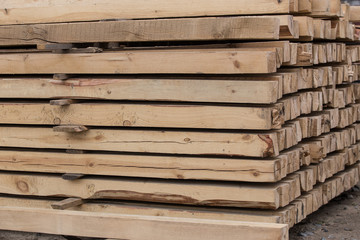 Wooden pine beams in a pile outside.