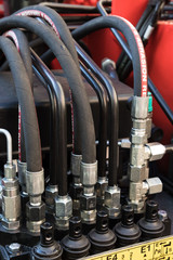 Detail of hydraulic hoses, couplings and fittings on an industrial machine.