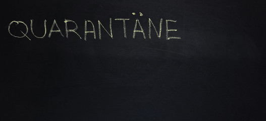 Obraz premium The word is in German quarantine. The text on the chalk Board. Yellow chalk. banner