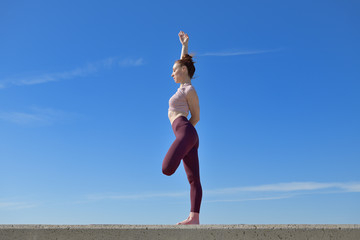 Portrait of a fit woman who practices yoga outdoors. Woman practicing asanas on a sunny day