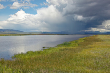 Fototapeta na wymiar Storm clouds over grasslands and mountains at Red Rock Lake in Centennial Valley, near Lakeview, MT
