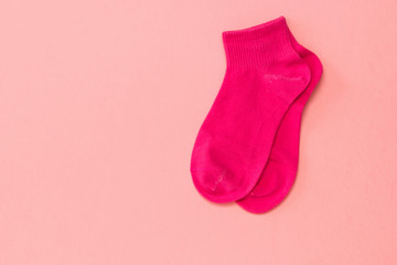 Red sports socks on a bright pink background. Flat lay.
