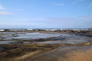 Fototapeta na wymiar Waves Breaking on Susan Gilmore Beach at Low Tide