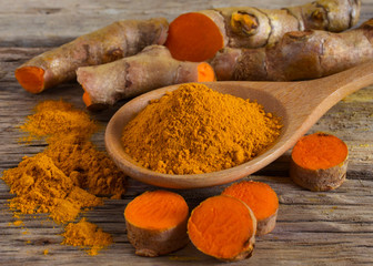 Turmeric powder and fresh turmeric (curcumin) on wooden background,Used for cooking and as herbal...