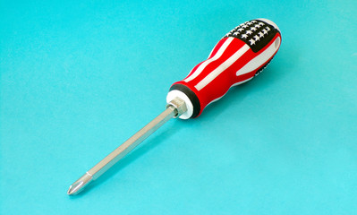 Screwdriver. Screwdriver close- up on a colored background. Hand- held screwdriver for tightening bolts and screws.