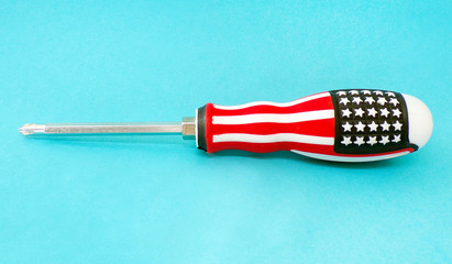 A screwdriver in the design of the American flag . Screwdriver close -up. Concept of repair and construction . Screw driver for tightening bolts and screws .