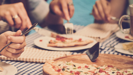 Fototapeta premium Closeup of young woman eating delicious pizza at their girlish party