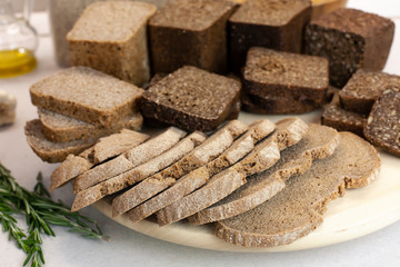 Different varieties of bread on the kitchen table on a light background